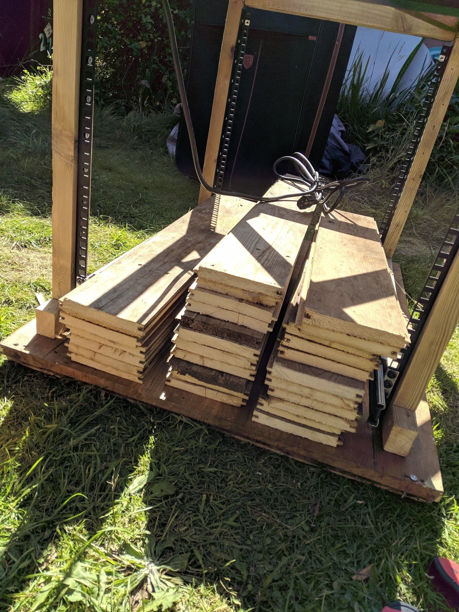 An image of all of the planks of wood completed, resting inside the in-progress cabinet