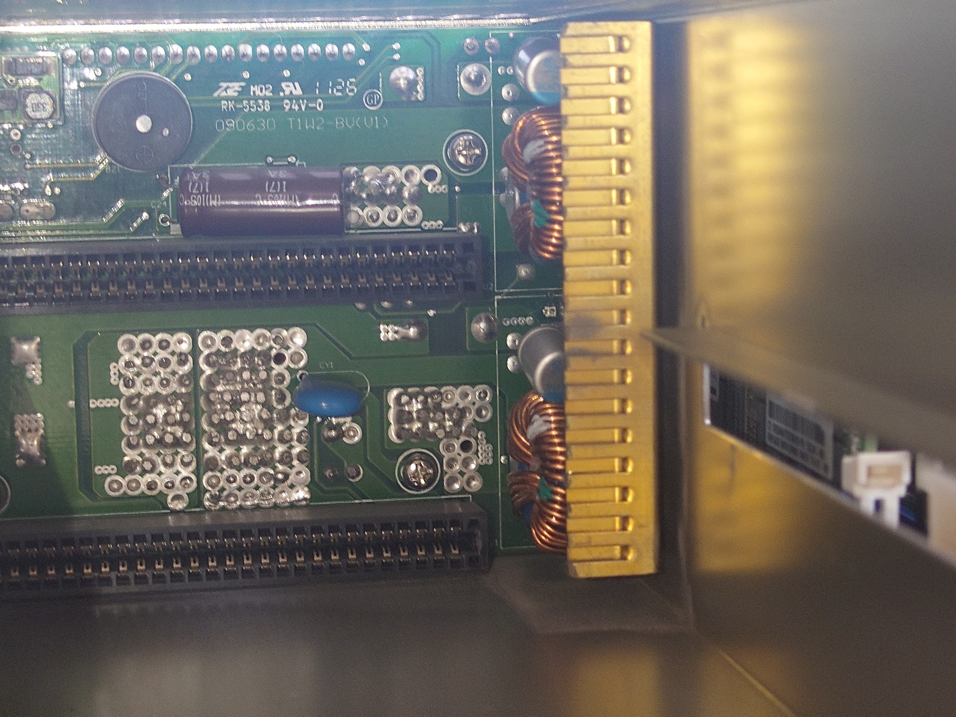 A close-up view of electronic circuit boards housed in a metallic case, featuring various components and connectors with a scorch mark in the middle.